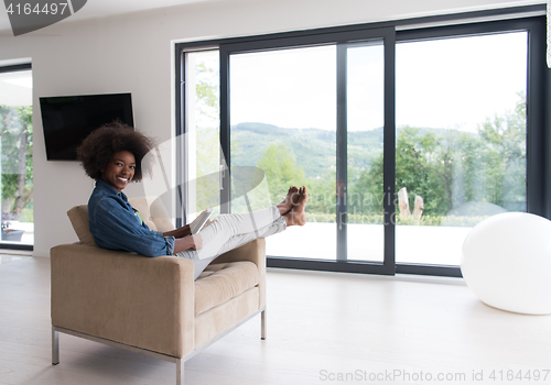 Image of african american woman at home with digital tablet