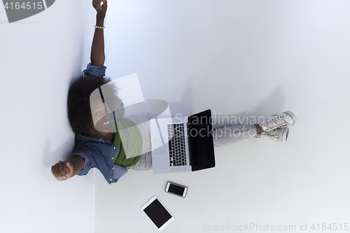 Image of african american woman sitting on floor with laptop top view
