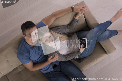 Image of youg couple in living room with tablet top view