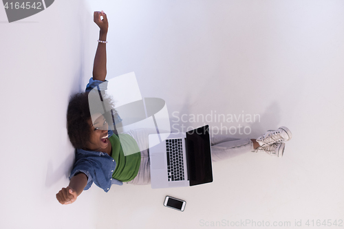 Image of african american woman sitting on floor with laptop top view