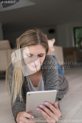 Image of young women used tablet computer on the floor