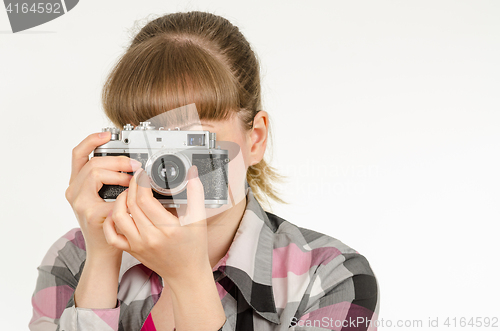 Image of The girl photographer photographing the old film camera