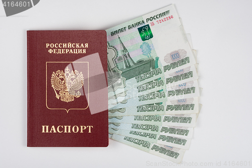Image of Passport and money fanned out on a white background