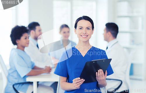 Image of happy doctor over group of medics at hospital