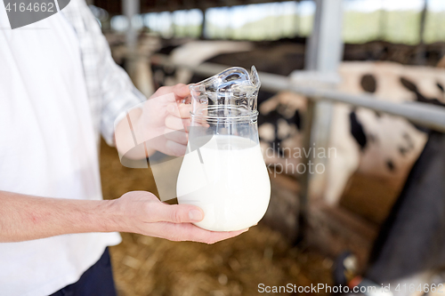 Image of close up of man or farmer with milk on dairy farm