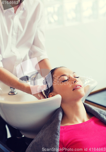 Image of happy young woman at hair salon