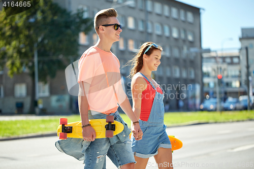 Image of teenage couple with skateboards on city street