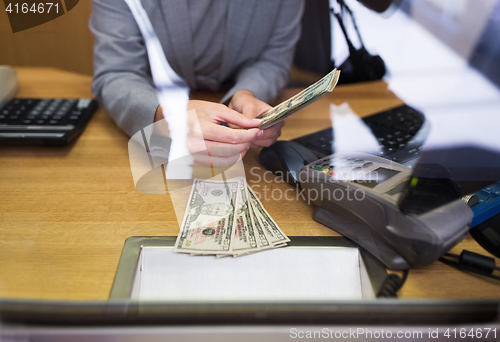 Image of clerk giving cash money to customer at bank office