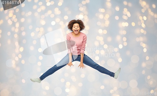 Image of happy african american woman jumping over white