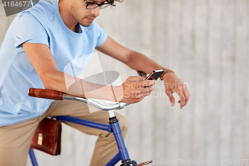 Image of man with smartphone and fixed gear bike on street