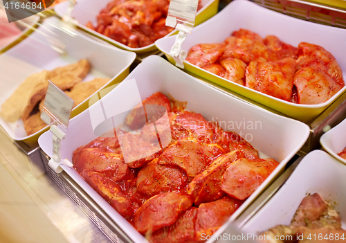 Image of marinated meat in bowls at grocery stall