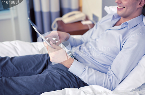 Image of businessman with tablet pc at hotel room