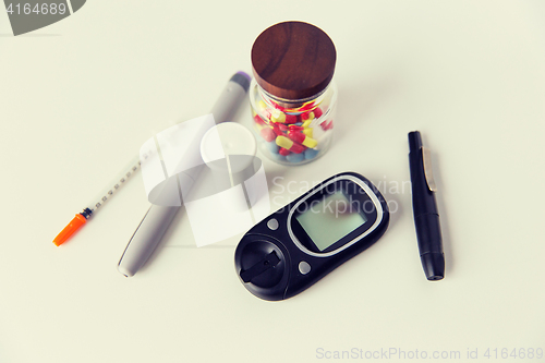 Image of close up of glucometer, insulin pen and drug pills