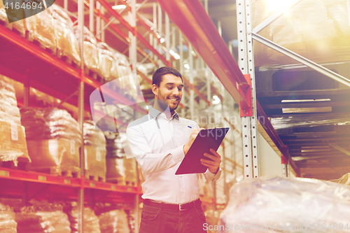 Image of businessman with clipboard at warehouse