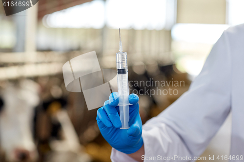 Image of veterinarian hand with vaccine in syringe on farm