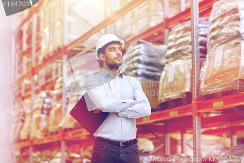 Image of happy businessman with clipboard at warehouse