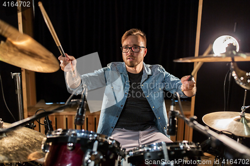 Image of male musician playing drums and cymbals at concert