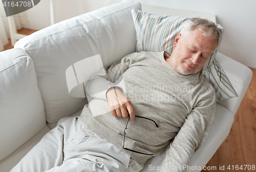 Image of senior man sleeping on sofa at home