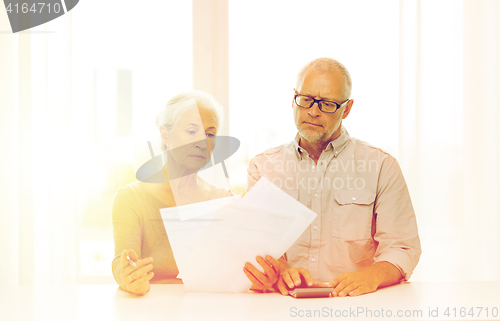 Image of senior couple with papers and calculator at home