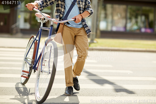 Image of young man with fixed gear bicycle on crosswalk