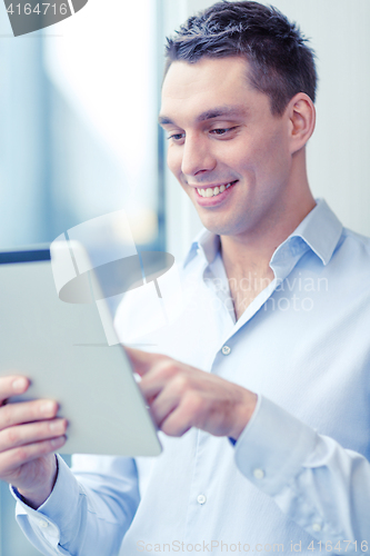 Image of smiling businessman with tablet pc in office