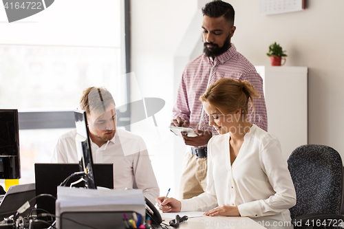 Image of happy creative team working at office