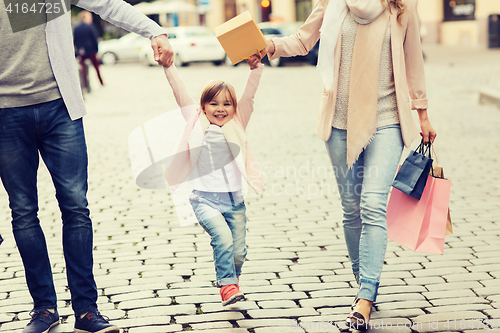 Image of happy family with child and shopping bags in city