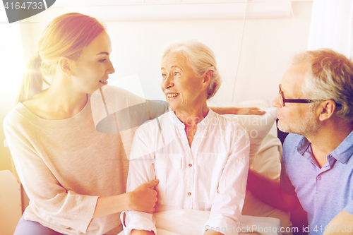 Image of happy family visiting senior woman at hospital