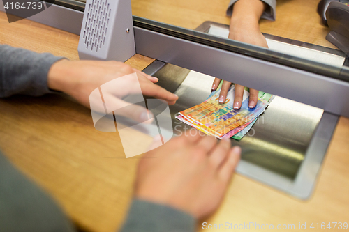 Image of clerk giving cash money to customer at bank office