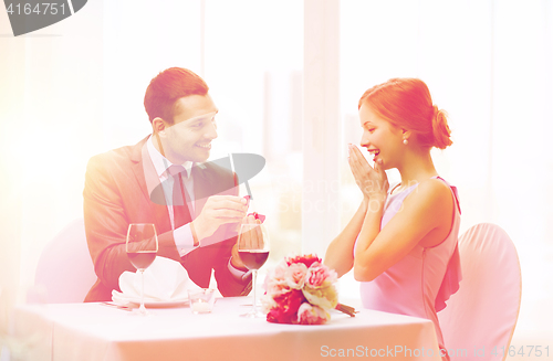 Image of man proposing to his girlfriend at restaurant