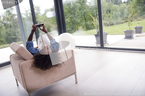 Image of african american woman at home with digital tablet