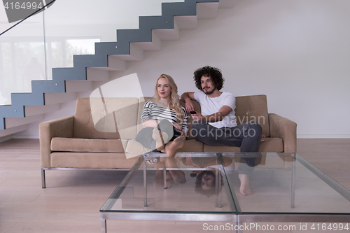 Image of Young couple on the sofa watching television