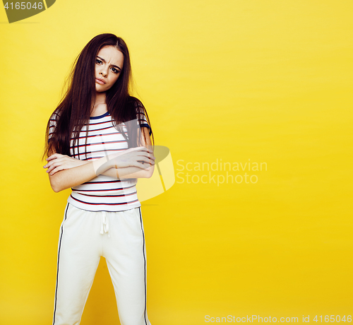 Image of young pretty teenage woman emotional posing on yellow background, fashion lifestyle people concept 