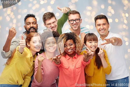 Image of international group of people showing thumbs up