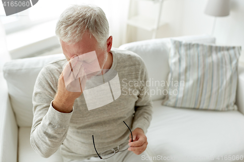 Image of senior man suffering from headache at home