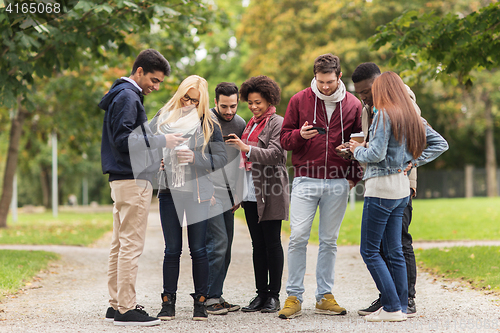 Image of happy friends with smartphone and coffee outdoors