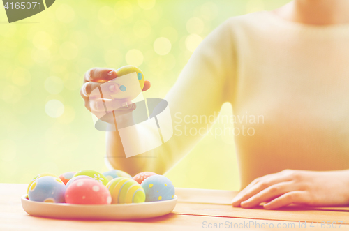 Image of close up of woman hands with colored easter eggs