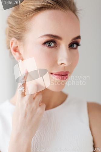 Image of smiling woman in white dress with diamond jewelry