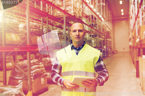 Image of manual worker with tablet pc at warehouse