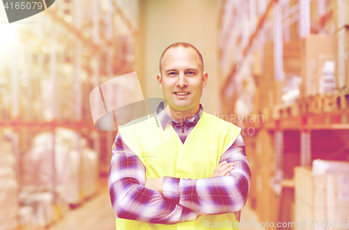 Image of happy man in reflective safety vest at warehouse