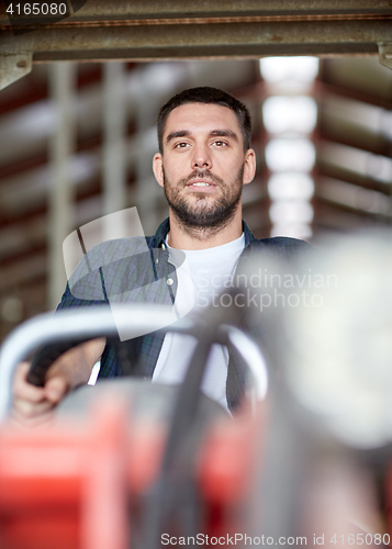 Image of man or farmer driving tractor at farm