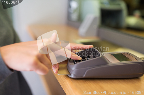 Image of close up of hand entering code to money terminal