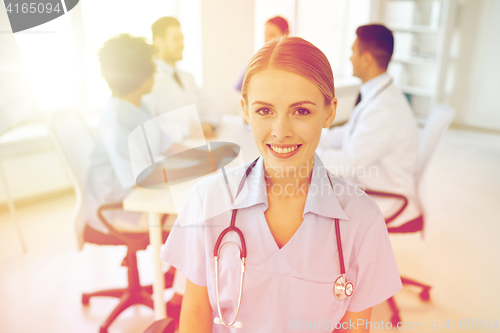 Image of happy doctor over group of medics at hospital