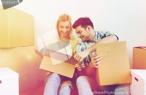 Image of smiling couple with many boxes moving to new home