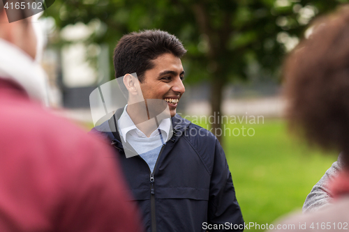 Image of happy friends walking along autumn park