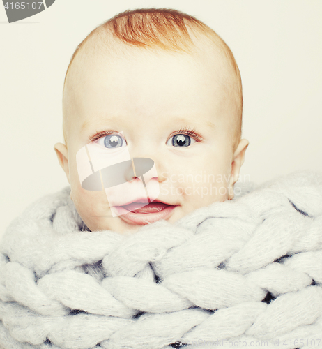 Image of little cute red head baby in scarf all over him close up isolate