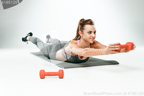 Image of Beautiful slim brunette doing some stretching exercises