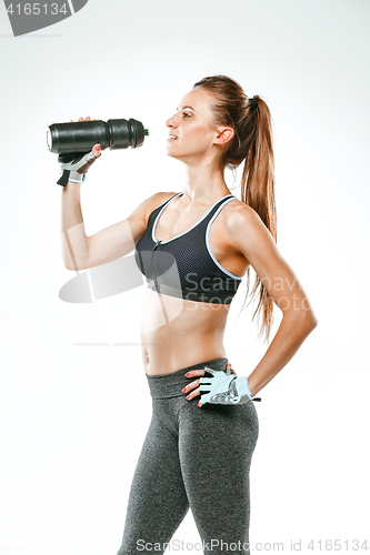 Image of Muscular young woman athlete with a water on black