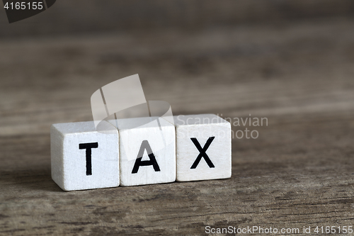 Image of Tax, written in cubes on wooden background