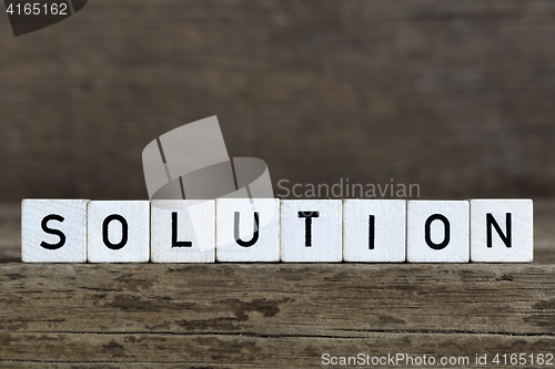 Image of Solution, written in cubes on wooden background